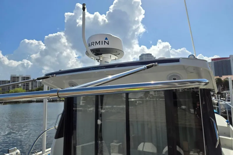  Yacht Photos Pics 2020 Jeanneau NC 1095 boat with Garmin radar, docked under a cloudy sky.