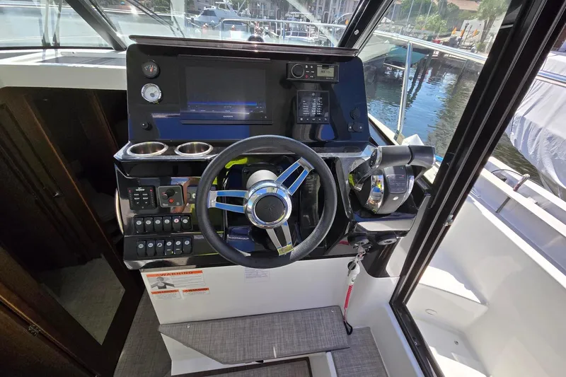  Yacht Photos Pics Helm of 2020 Jeanneau NC 1095 boat with steering wheel and navigation controls.