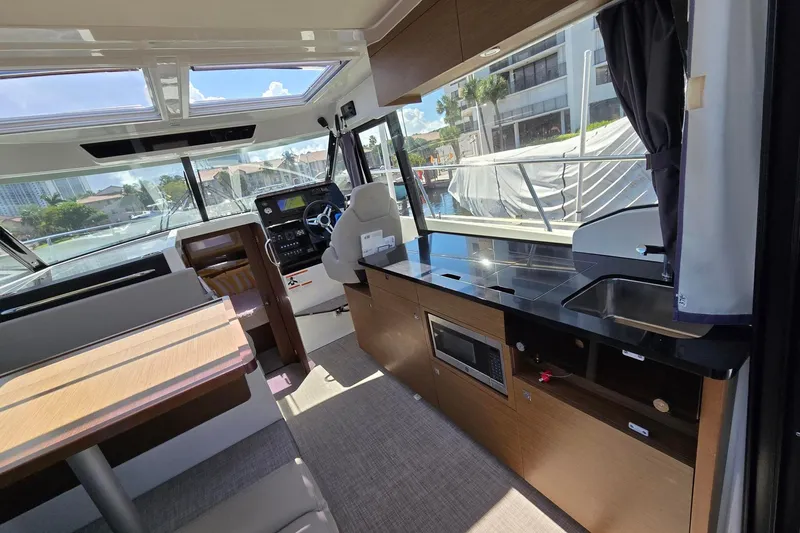  Yacht Photos Pics Interior of 2020 Jeanneau NC 1095 boat with modern kitchen and helm station.