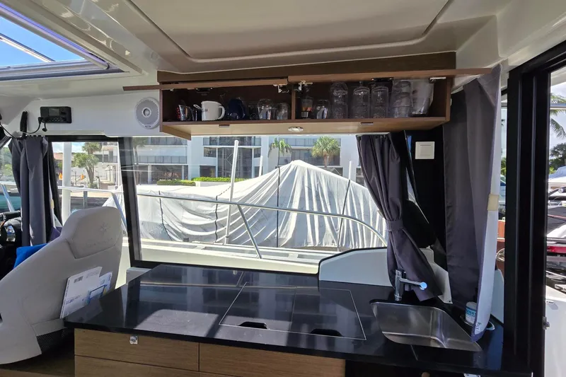  Yacht Photos Pics Interior of 2020 Jeanneau NC 1095 boat with kitchenette and glass storage.