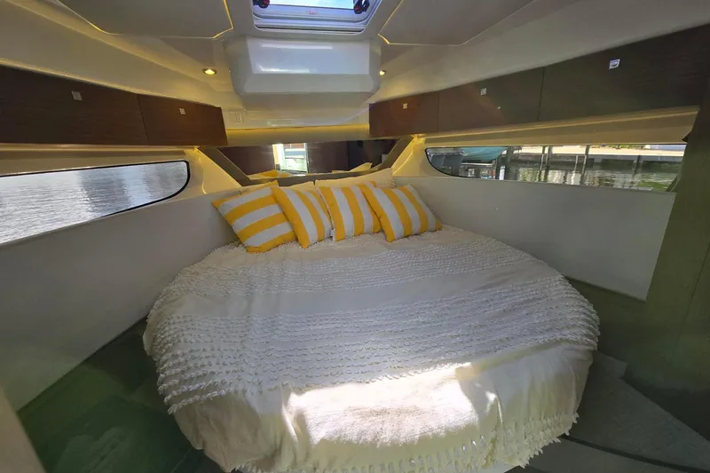  Yacht Photos Pics Cozy cabin interior of 2020 Jeanneau NC 1095 with striped pillows and soft bedding.