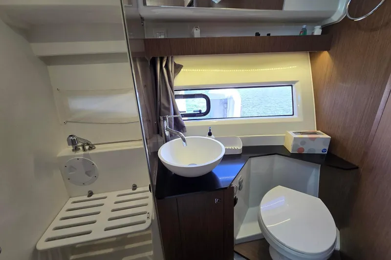  Yacht Photos Pics 2020 Jeanneau NC 1095 boat bathroom with sink, toilet, and window view.