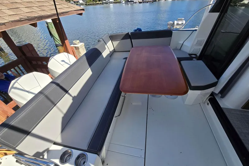  Yacht Photos Pics 2020 Jeanneau NC 1095 boat with spacious seating and wooden table on deck.
