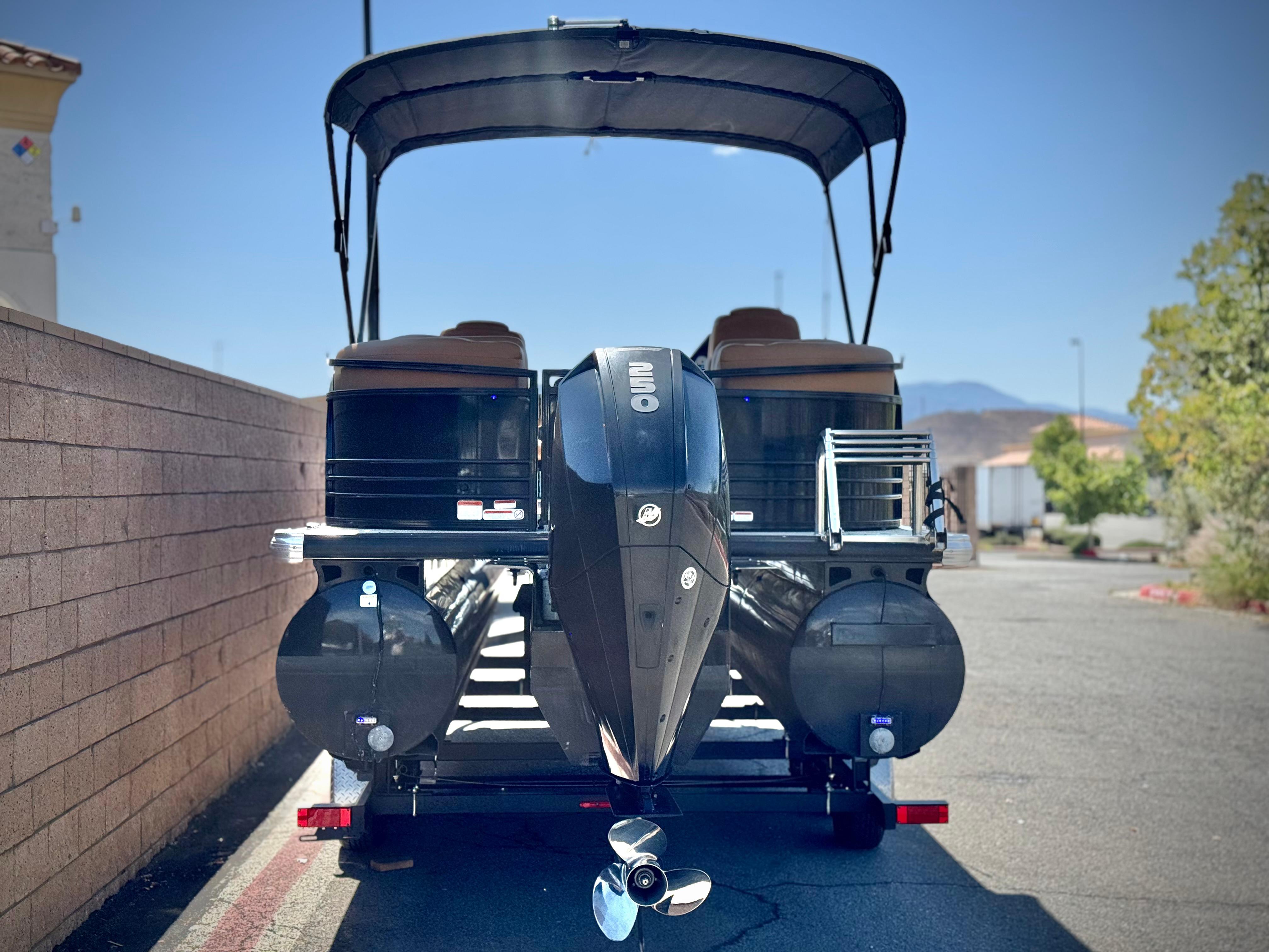 2021 Regency 230 LE3 pontoon boat with outboard motor, parked outdoors.
