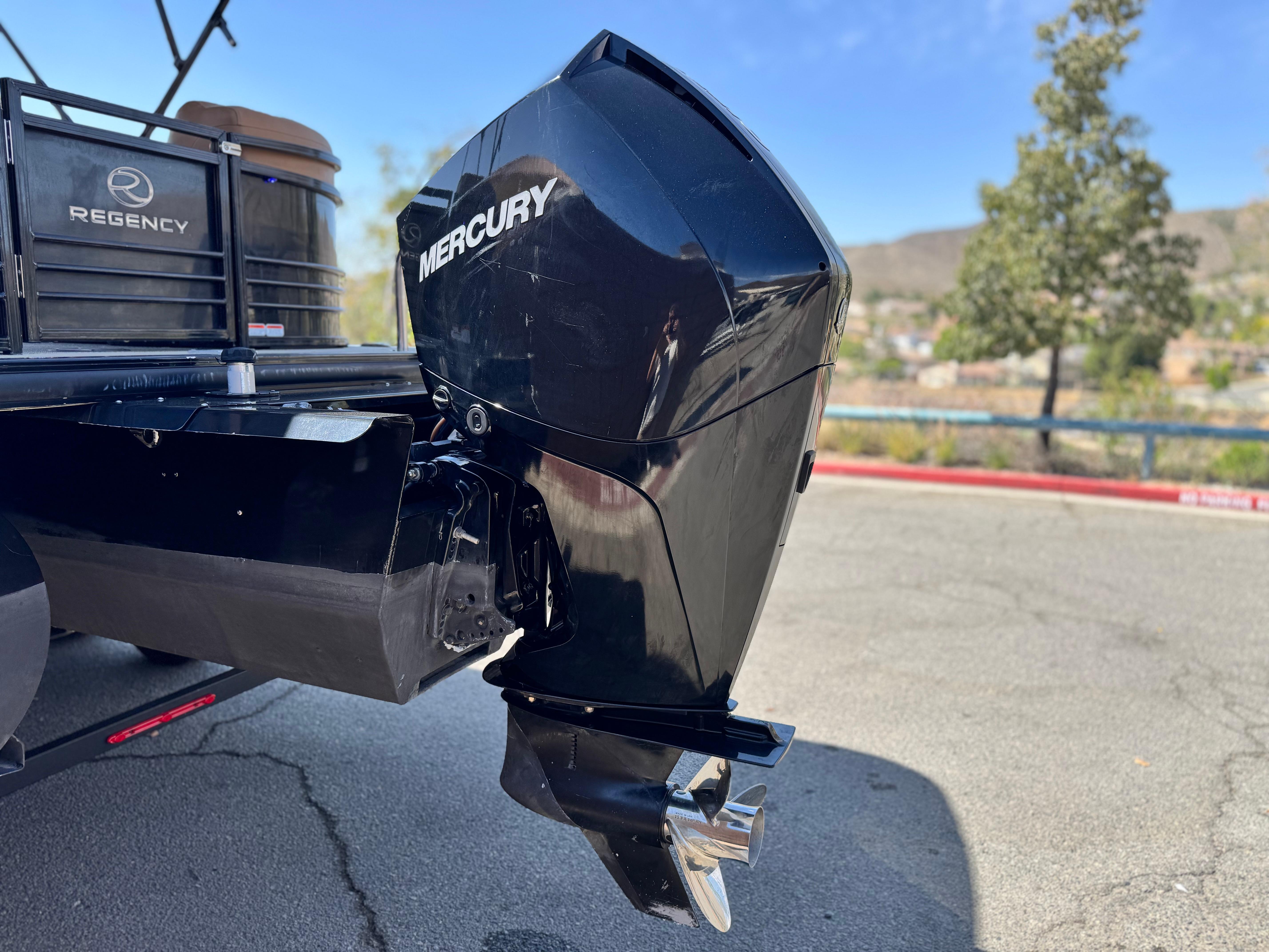 2021 Regency 230 LE3 boat with Mercury outboard motor, parked outdoors.