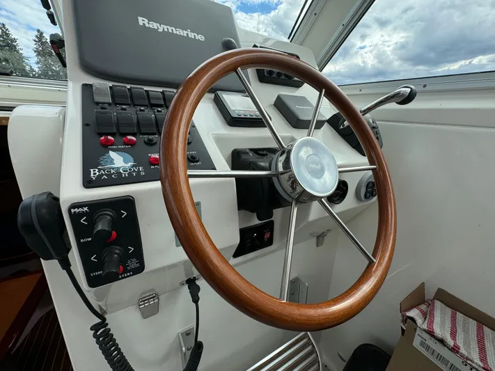 "flying Low" Yacht Photos Pics Helm of 2008 Back Cove 33 yacht with wooden steering wheel and Raymarine controls.