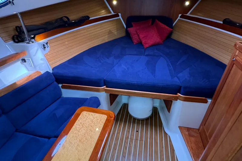 "flying Low" Yacht Photos Pics 2008 Back Cove 33 interior with blue seating, wooden accents, and cozy sleeping area.