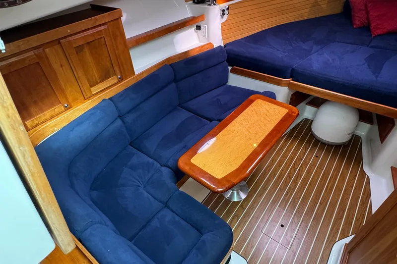 "flying Low" Yacht Photos Pics 2008 Back Cove 33 interior with blue seating, wooden table, and cabinetry.