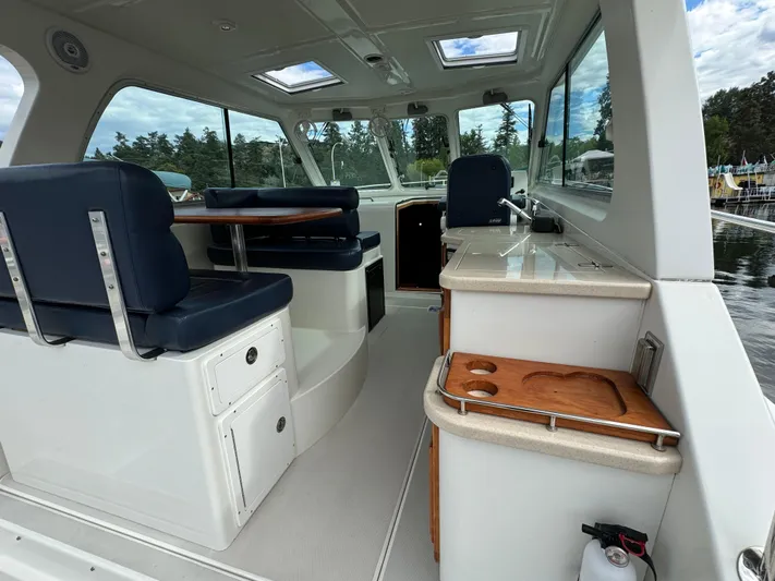 "flying Low" Yacht Photos Pics 2008 Back Cove 33 boat interior with seating, table, and kitchenette.