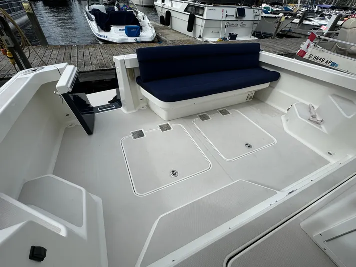 "flying Low" Yacht Photos Pics 2008 Back Cove 33 boat deck with seating and storage compartments at a marina.