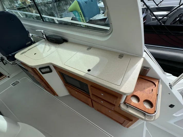 "flying Low" Yacht Photos Pics 2008 Back Cove 33 yacht interior with kitchenette, featuring countertop, storage, and cup holders.