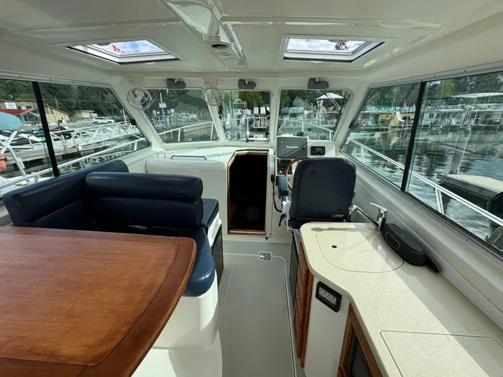 "flying Low" Yacht Photos Pics Interior of 2008 Back Cove 33 boat with seating, helm, and windows overlooking marina.