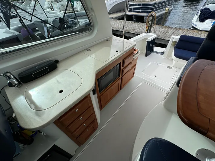 "flying Low" Yacht Photos Pics Interior of 2008 Back Cove 33 boat with kitchenette and seating area.
