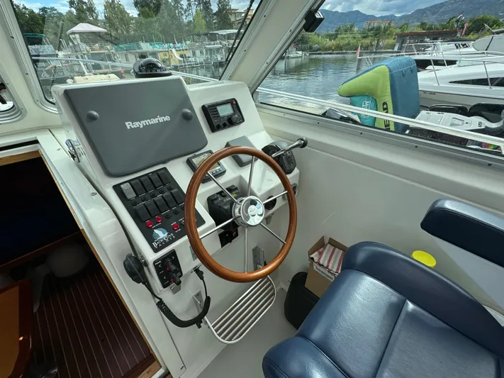"flying Low" Yacht Photos Pics Helm of 2008 Back Cove 33 boat with Raymarine navigation system and wooden steering wheel.