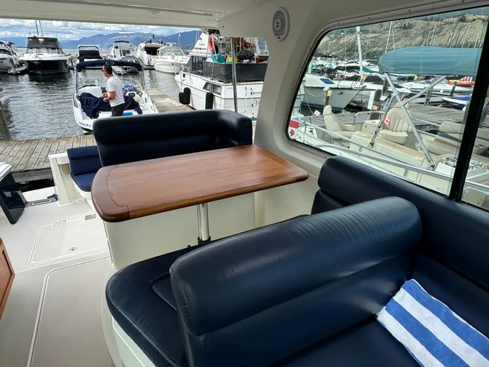 "flying Low" Yacht Photos Pics Interior of 2008 Back Cove 33 yacht with blue seating and wooden table.