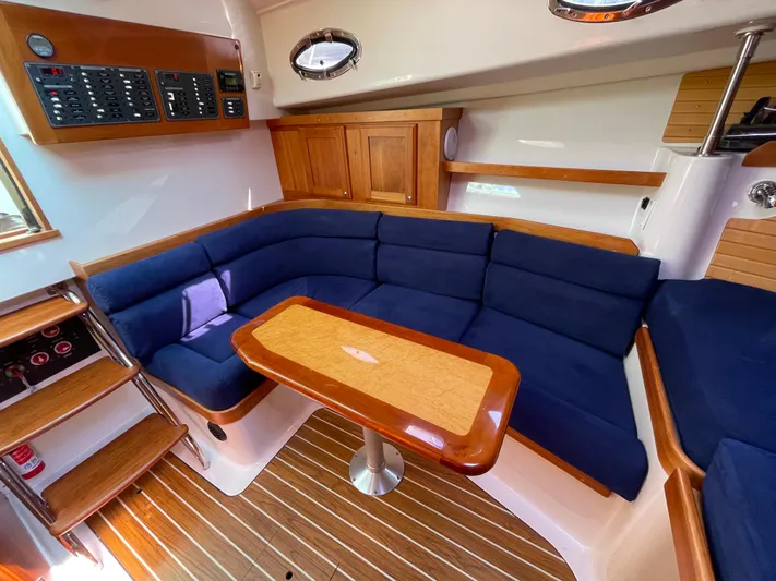 "flying Low" Yacht Photos Pics Interior of 2008 Back Cove 33 yacht with blue seating and wooden table.