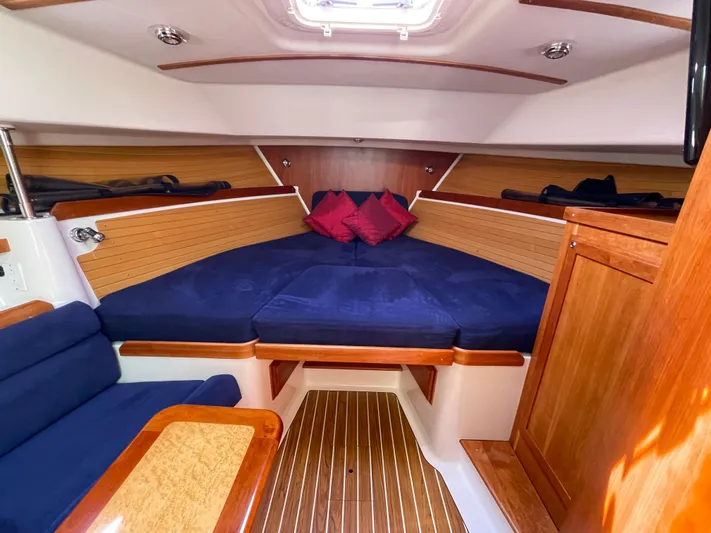 "flying Low" Yacht Photos Pics 2008 Back Cove 33 interior cabin with blue seating and wooden accents.