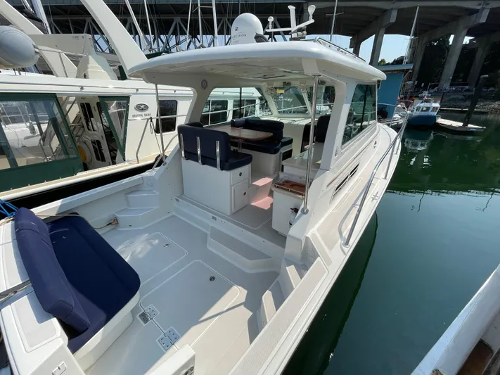 "flying Low" Yacht Photos Pics 2008 Back Cove 33 boat docked, featuring spacious deck and seating under a covered area.