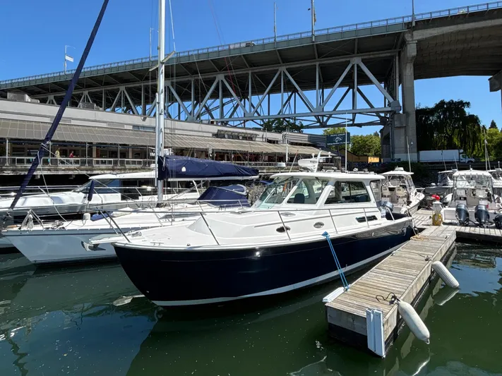 "flying Low" Yacht Photos Pics 2008 Back Cove 33 boat docked under a bridge in a marina.