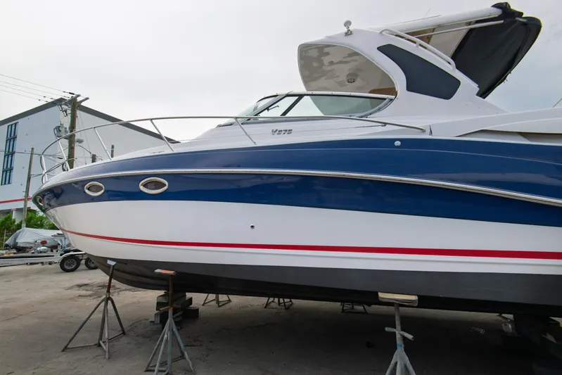  Yacht Photos Pics 2014 Four Winns V375 boat on stands, blue and white hull, outdoor setting.