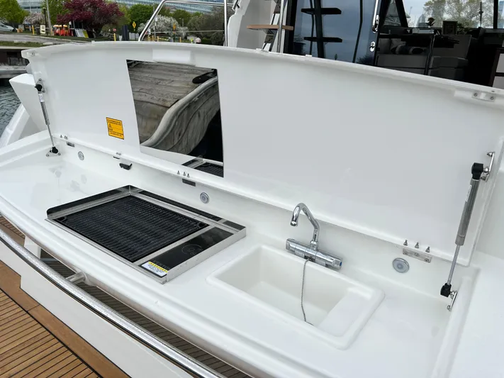  Yacht Photos Pics Outdoor kitchen on 2023 Prestige 460 Flybridge yacht with grill and sink.