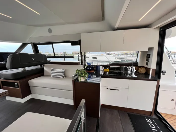  Yacht Photos Pics Luxurious interior of 2023 Prestige 460 Flybridge yacht with modern kitchen and seating area.