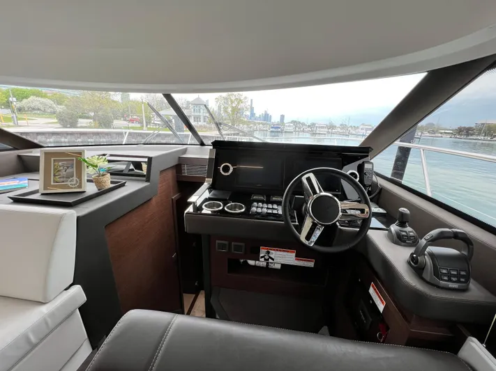  Yacht Photos Pics Interior view of 2023 Prestige 460 Flybridge yacht helm with modern controls and scenic waterway.
