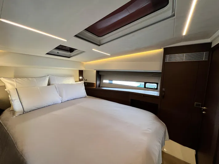  Yacht Photos Pics Luxurious bedroom interior of 2023 Prestige 460 Flybridge yacht, featuring elegant bedding and modern design.