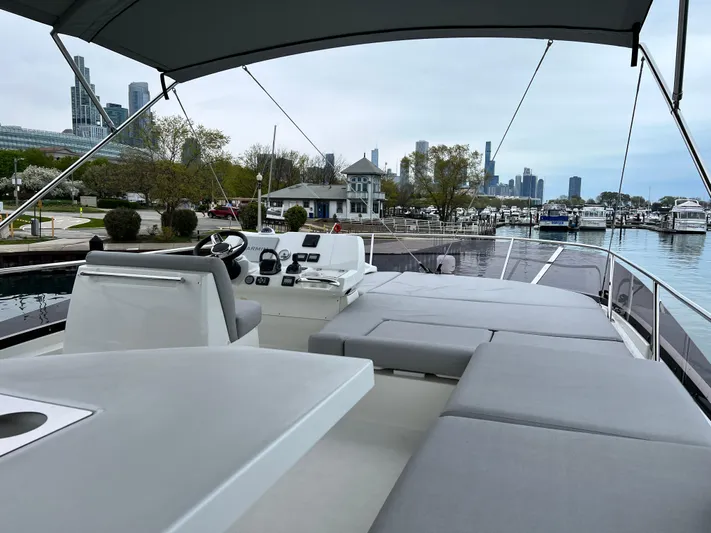  Yacht Photos Pics 2023 Prestige 460 Flybridge yacht with spacious deck, city skyline in background.