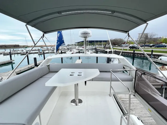  Yacht Photos Pics Prestige 460 Flybridge 2023 yacht with seating area and table at marina.