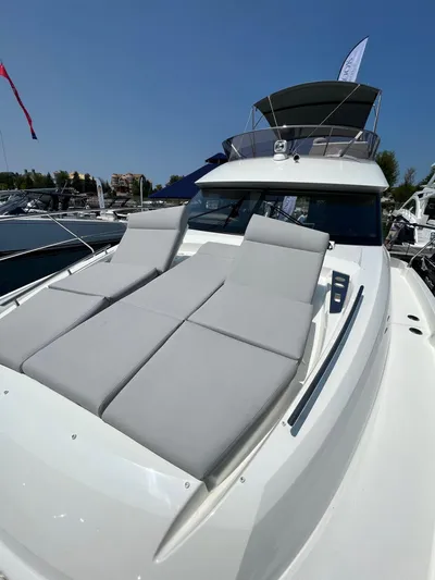  Yacht Photos Pics 2023 Prestige 460 Flybridge yacht with sun loungers, showcased at a marina.