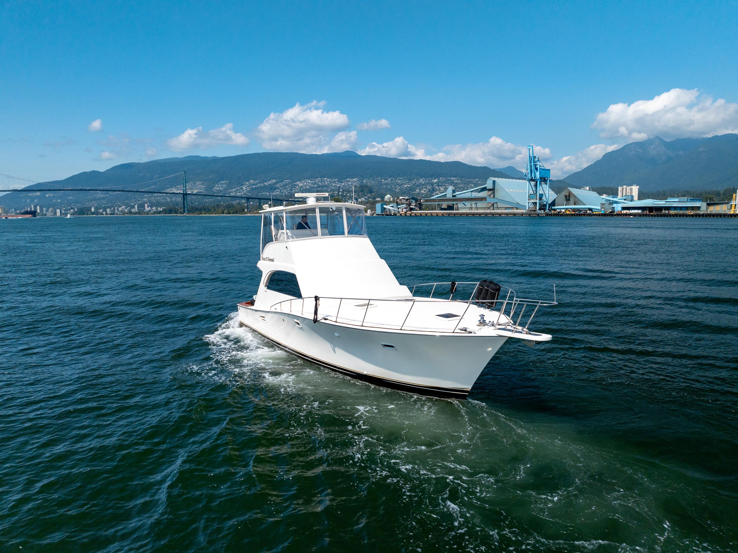 1985 Post 46 Convertible yacht cruising on open water with mountain backdrop.