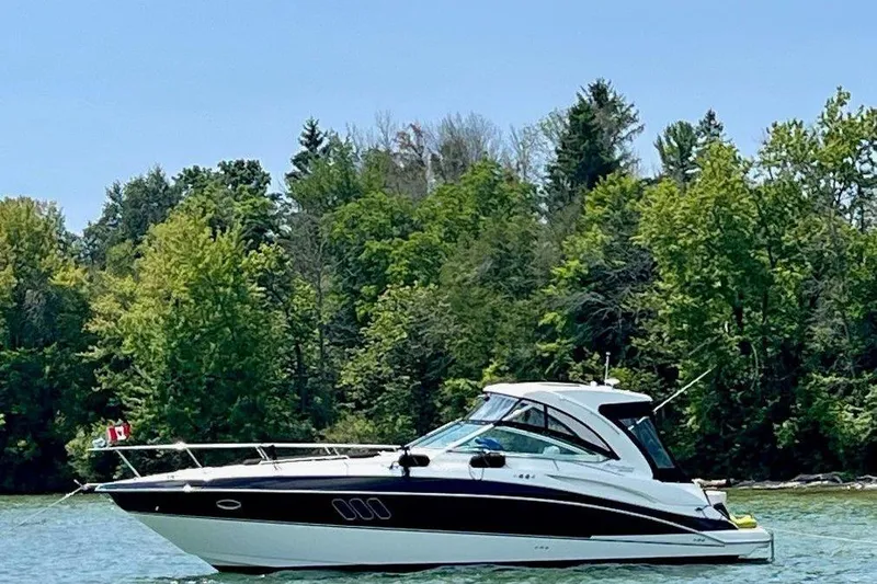  Yacht Photos Pics 2012 Cruisers Yachts 380 Express on a serene lake with lush green trees.