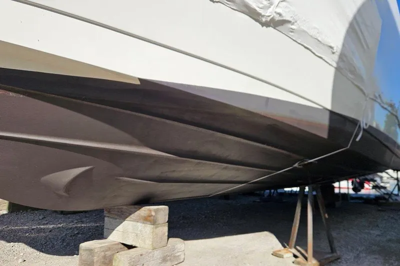  Yacht Photos Pics 2012 Cruisers Yachts 380 Express hull on dry dock, supported by wooden blocks.