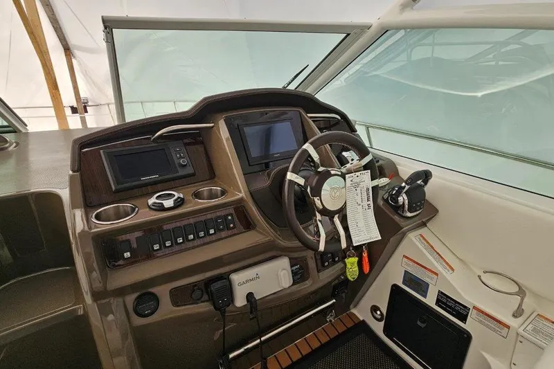 Yacht Photos Pics 2012 Cruisers Yachts 380 Express helm with steering wheel and navigation controls.