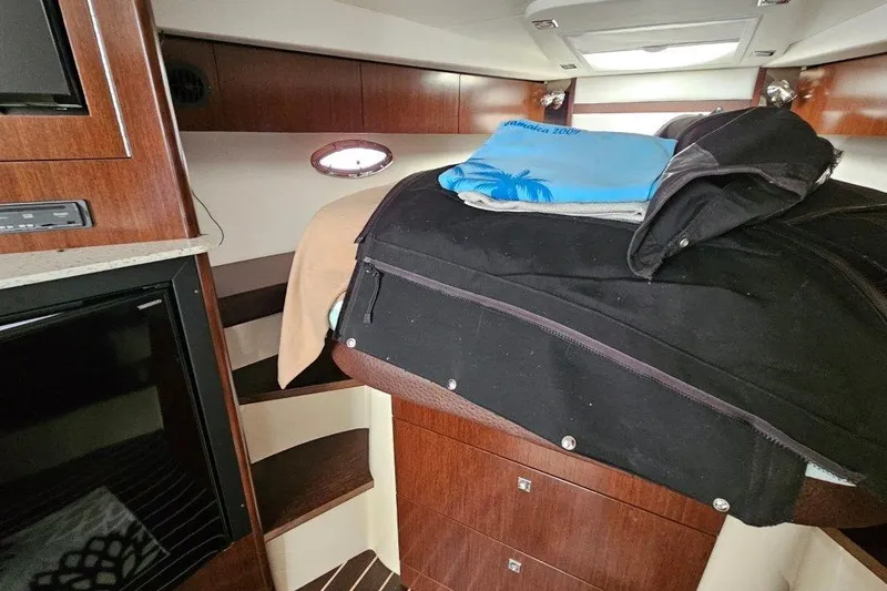  Yacht Photos Pics Interior of 2012 Cruisers Yachts 380 Express with wooden cabinetry and luggage on bed.