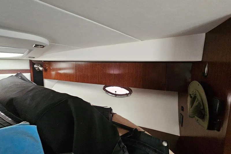  Yacht Photos Pics Interior cabin of 2012 Cruisers Yachts 380 Express with wood paneling and porthole.