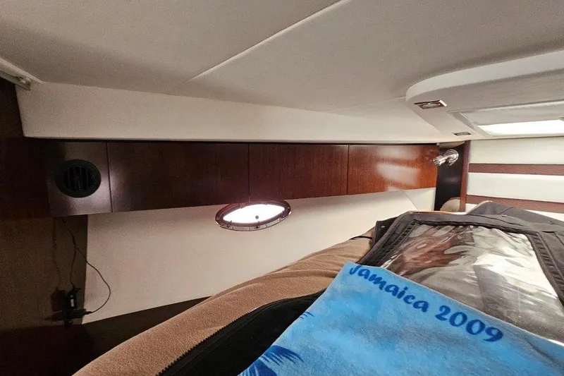  Yacht Photos Pics Interior cabin of 2012 Cruisers Yachts 380 Express with wood paneling and porthole.