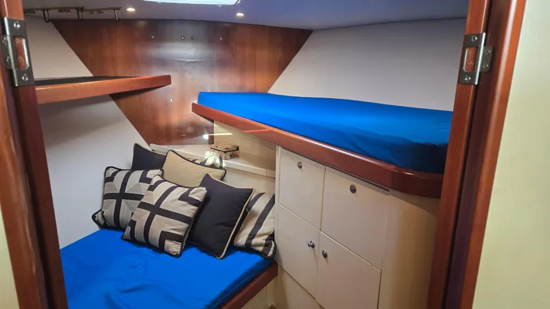 Rack Em Up Yacht Photos Pics Cozy cabin interior of 2008 Ocean Yachts 37 Billfish with blue bedding and decorative pillows.