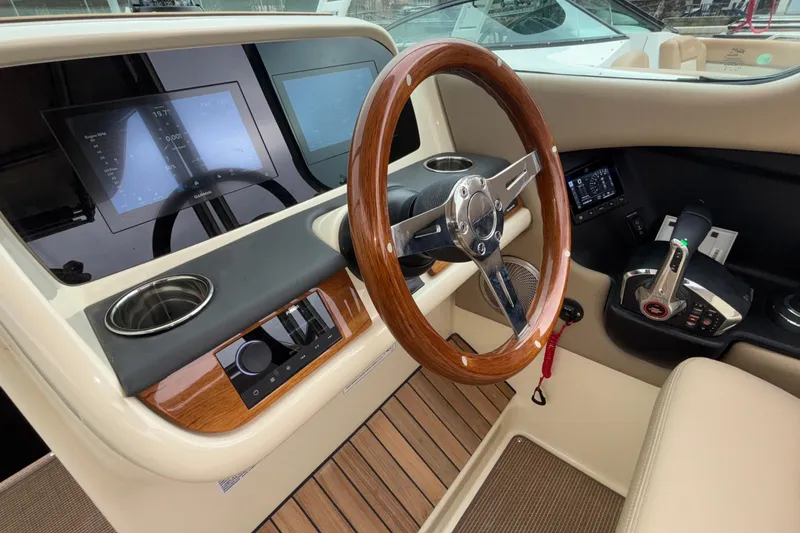  Yacht Photos Pics 2026 Chris-Craft Calypso 28 helm with wooden steering wheel and modern controls.