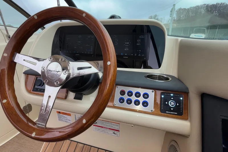  Yacht Photos Pics 2026 Chris-Craft Calypso 28 helm with wooden steering wheel and modern controls.
