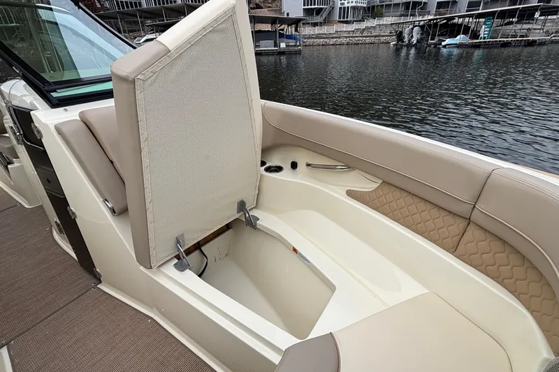  Yacht Photos Pics 2026 Chris-Craft Calypso 28 boat interior with open storage compartment by the water.