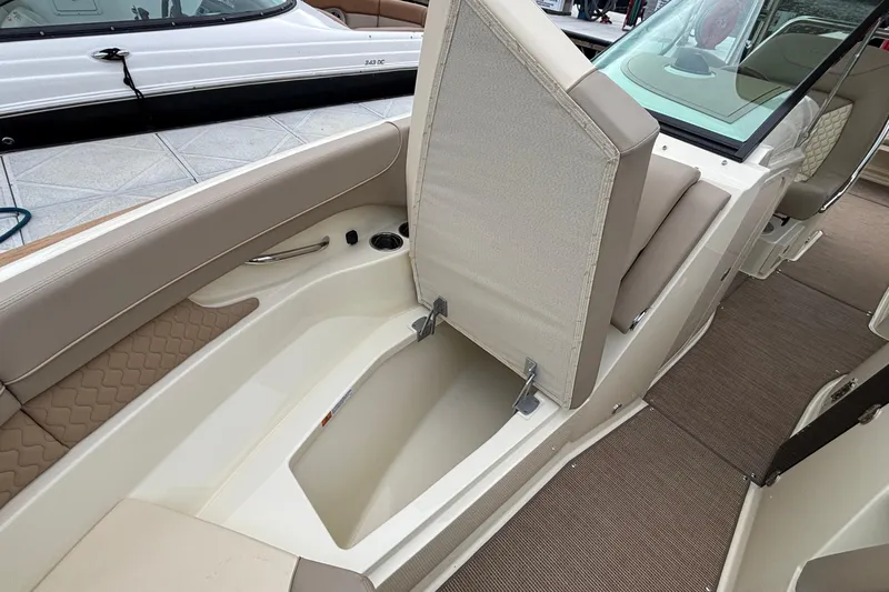  Yacht Photos Pics 2026 Chris-Craft Calypso 28 boat interior with open storage compartment and beige seating.