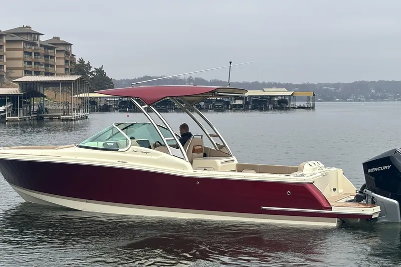  Yacht Photos Pics 2026 Chris-Craft Calypso 28 boat on a calm lake near docks and buildings.