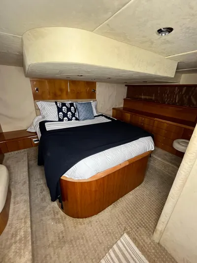  Yacht Photos Pics Luxurious bedroom interior of 2002 Sunseeker Predator 61 yacht with elegant wood finishes.