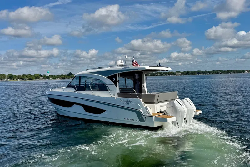 Venture Yacht Photos Pics 2024 Beneteau Antares 11 cruising on a sunny day with scenic water backdrop.