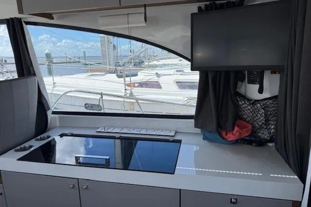 Venture Yacht Photos Pics Interior view of 2024 Beneteau Antares 11 with modern kitchen and window overlooking marina.