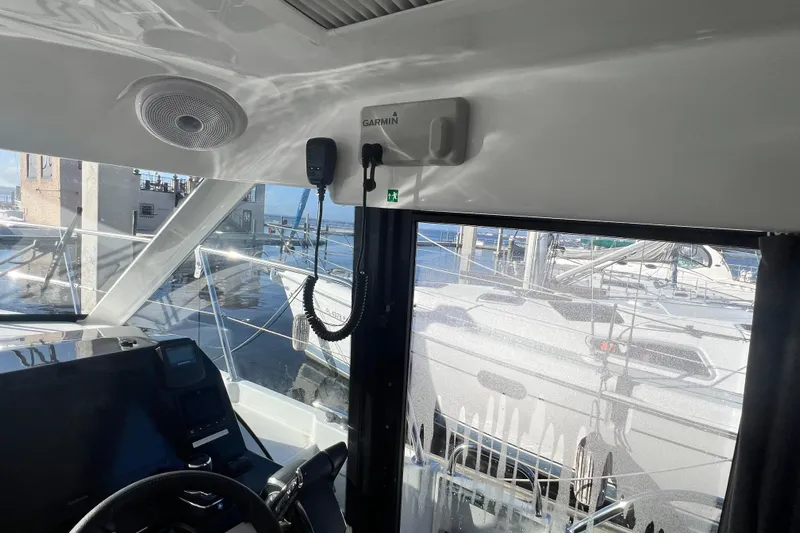 Venture Yacht Photos Pics Interior view of 2024 Beneteau Antares 11 boat with navigation equipment and marina background.