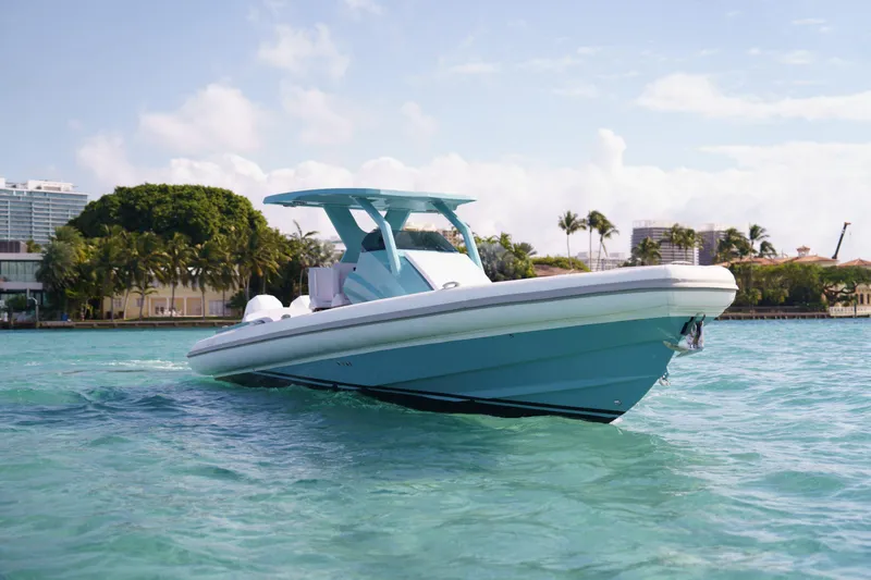 Novielli Yacht Photos Pics Novielli Veloche 2025 boat cruising on clear turquoise water near a tropical shoreline.