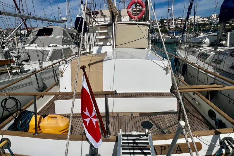 Apta Yacht Photos Pics 1989 Grand Banks 36 Classic yacht docked in a marina, featuring a wooden deck and nautical flag.